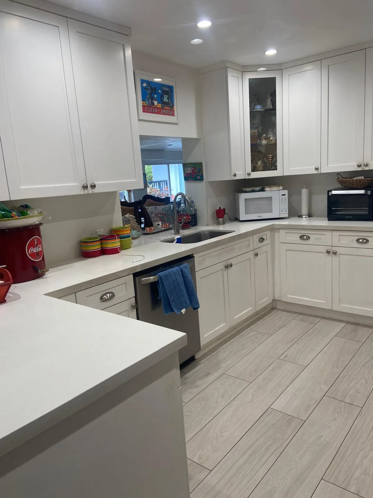 White kitchen with cabinets and counters wiped down and shining